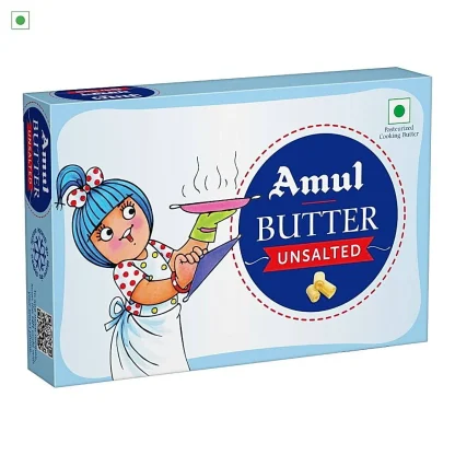 Creamy block of butter on a wooden board with a butter knife and herbs