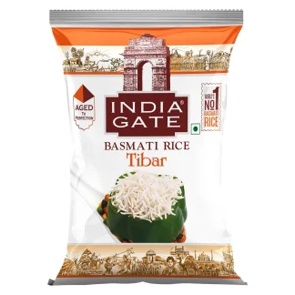 Raw long-grain basmati rice in a bowl with a few grains scattered for texture.