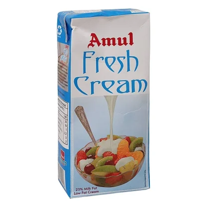 Fresh dairy cream in a bowl alongside a scoop of milk powder – ideal for recipes, beverages, and daily use.
