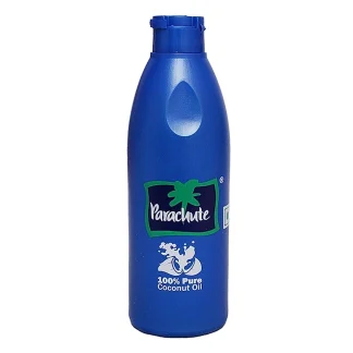 Bottle of herbal hair oil with coconut, amla, and neem on a wooden table