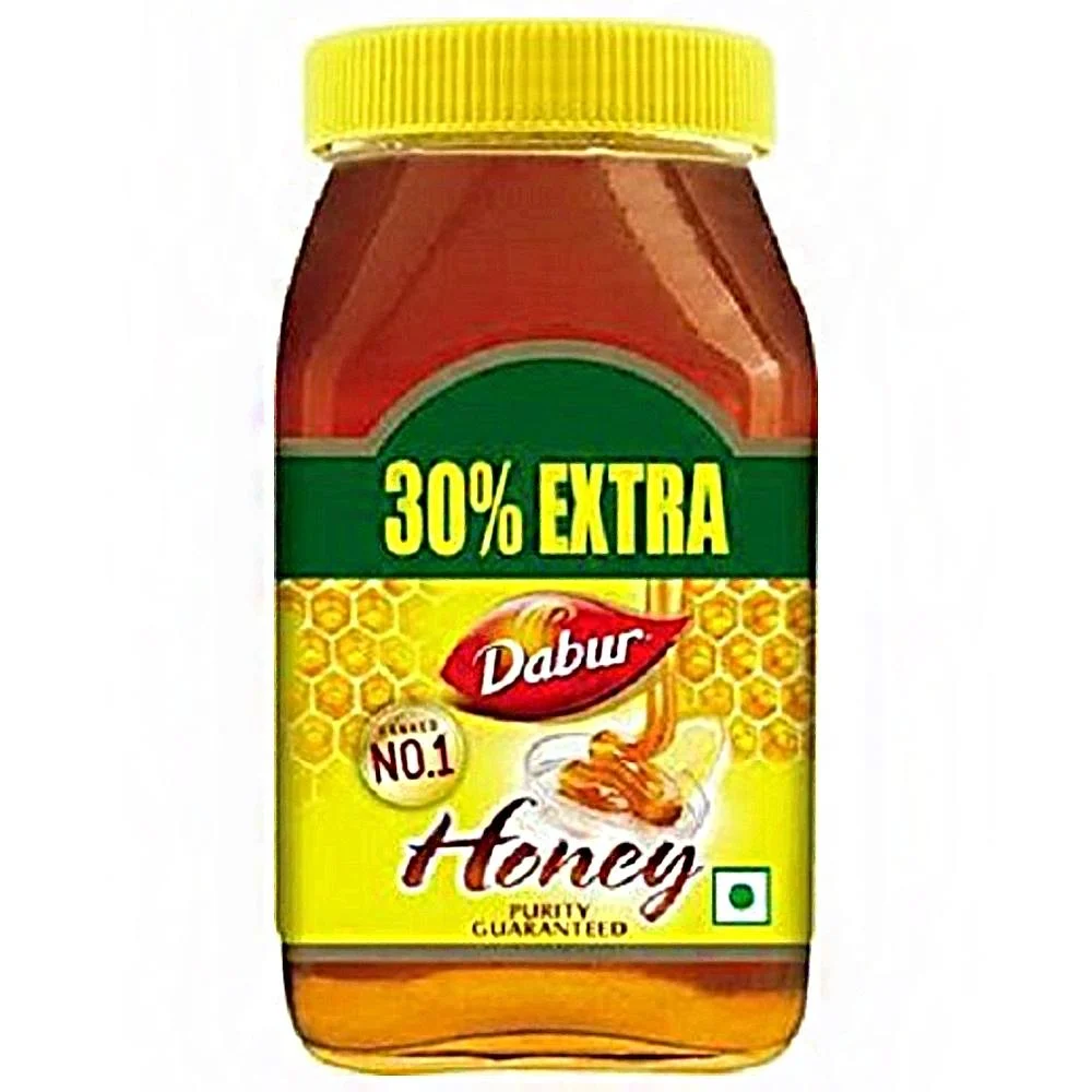 Pure natural honey in glass jars with a wooden honey dipper, surrounded by honeycomb pieces on a rustic table.