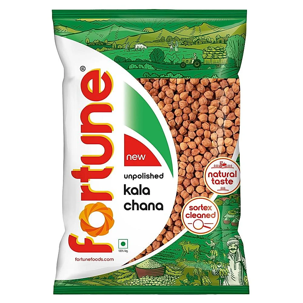 Kabuli chana or white chickpeas in a bowl with some scattered on a wooden surface